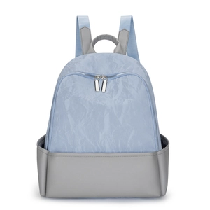 Blue and grey patchwork backpack with textured nylon surface and durable leather base