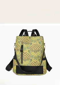 Detail of yellow brocade backpack with traditional cloud patterns and black leather trim