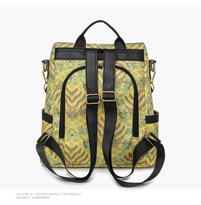 Detail of yellow brocade backpack with cloud patterns and black leather straps