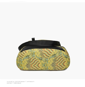 Detail of golden brocade chest bag with traditional Chinese cloud patterns and black strap