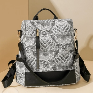 Detail view of stylish black and white wave pattern backpack with gold metal zippers
