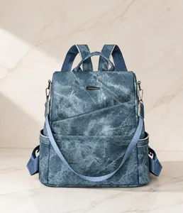 Vorderansicht blauer Rucksack mit Denim-Textur, Silberbeschlägen und schrägem Reißverschluss
