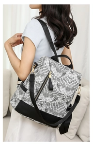 Detail of the black and white wave pattern backpack with gold hardware on a female model