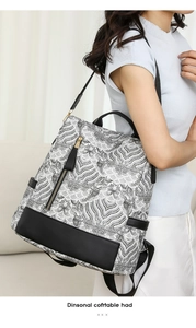 Detail of a versatile backpack with black and white wave pattern and gold zipper hardware