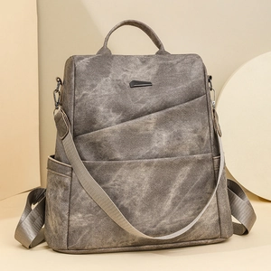 Makroaufnahme des grauen PU-Lederrucksacks mit modernem geometrischem Metall-Logo-Detail