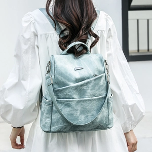 Detail eines hellgrünen PU-Lederrucksacks mit Vintage-Textur und vorderem Reißverschluss
