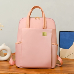 Sac à dos femme en nylon rose imperméable sur un bureau avec d'élégantes finitions dorées