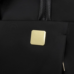 Détail du sac à dos en tissu oxford noir avec une plaque emblème carrée en métal doré