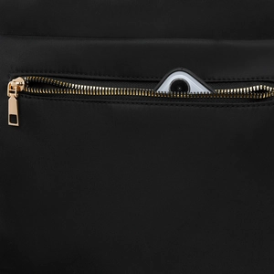 Détail du tissu en nylon noir avec fermeture éclair dorée et poche pour smartphone