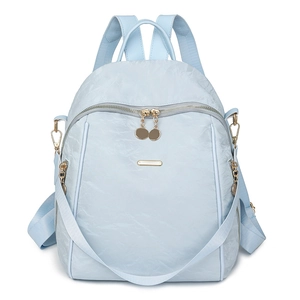 Detail of light blue Oxford fabric backpack with gold zippers and side pockets