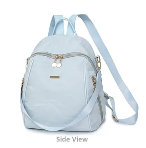 Side view of light blue oxford cloth backpack with gold zippers and polished hardware