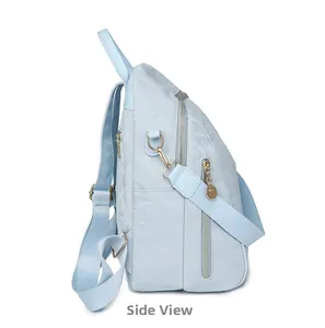 Side view of light blue oxford fabric backpack featuring gold zippers and wide straps