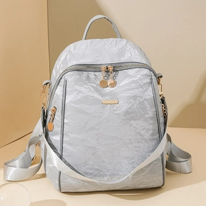 Detailed view of silver oxford backpack with gold zippers and detachable strap