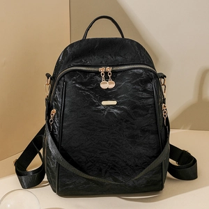 Detail of black oxford backpack showing golden metal hardware and crinkled texture
