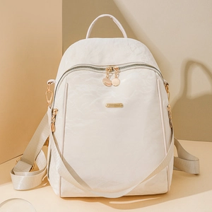 Close-up of cream oxford fabric texture with premium gold zippers on a stylish backpack
