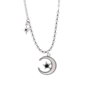 Detailed shot of silver moon and star pendant necklace with black gemstone inlay