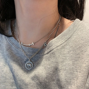 Detail view of retro 925 silver layered necklace with star and elephant coin charms