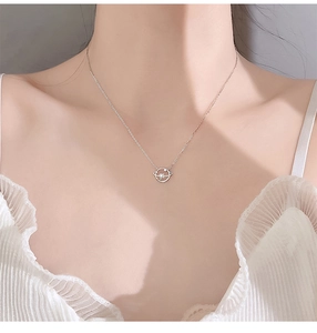 Close-up of a silver planet and star pendant necklace on a model's collarbone