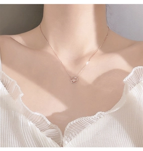 Close-up of a rose gold planet and star pendant necklace on a woman's collarbone
