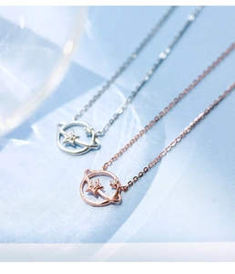 Close-up of star and planet necklaces in silver and rose gold finish on blue background