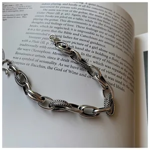 Retro chunky silver chain bracelet with textured twisted links on a vintage book background