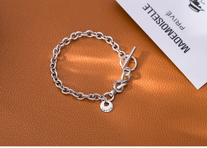 Close-up of S925 sterling silver chain bracelet with Lucky tag and toggle clasp
