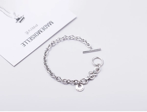 Macro detail of S925 sterling silver chain bracelet with Lucky tag and T-bar toggle clasp
