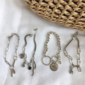 Vintage silver rabbit and letter charm bracelet set with various chain styles on white fabric
