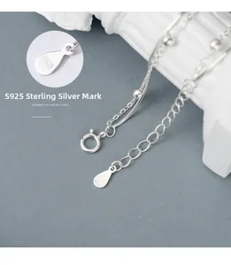 Macro shot of S925 sterling silver lobster clasp with hallmark tag and chain detail