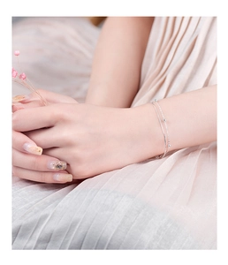 Close-up of a double-layer S925 silver snake chain bracelet with five polished beads