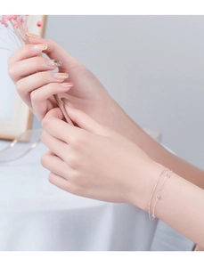 Detail of a double-layered S925 silver bracelet featuring tiny beads on a delicate chain