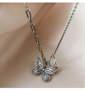 Detail der Vintage-Schmetterling-Halskette mit asymmetrischer Kette in Antik-Silber-Optik