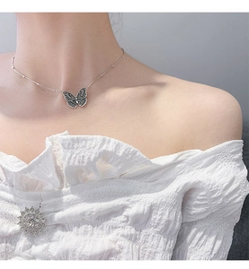 Detail der Vintage 925 Silber Schmetterling Kette mit Perlenkette am Hals einer Frau