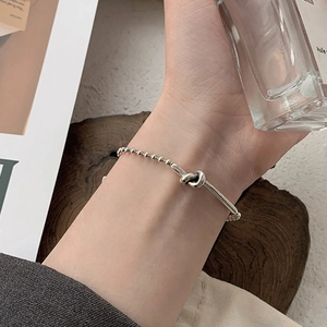 Minimalist S925 sterling silver knot bracelet with ball chain on model's wrist