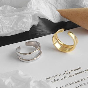 Double layered wave open ring in gold and silver finish on a minimalist background