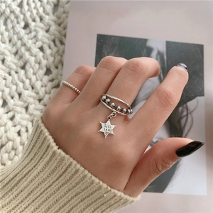 Détail d'une bague multicouche en argent S925 avec pendentif étoile et gravure