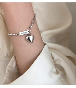 Détail du bracelet en argent S925 avec pendentif coeur et gravure Lucky Girl élégante