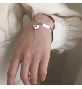 Détail d'un bracelet vintage en argent avec pendentif cœur sur le poignet
