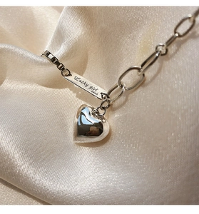 Détail du collier cœur en argent S925 avec plaque Lucky Girl gravée sur tissu en soie