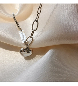 Détail du collier cœur en argent S925 avec plaque Lucky Girl sur tissu en soie