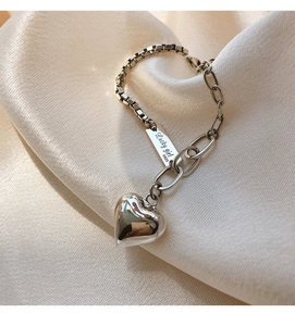Détail du bracelet en argent S925 avec plaque Lucky Girl et breloque cœur sur satin