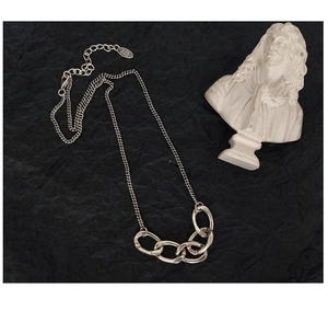 Dettaglio della collana in argento 925 con maglie ovali su sfondo nero strutturato