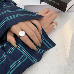 Detail of s925 silver minimalist wide ring with mother of pearl inlay on model hand