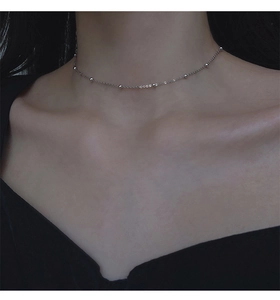 Collier minimaliste à billes d'argent sur mannequin montrant l'élégance de la chaîne