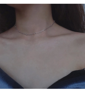 Gros plan du collier ras de cou minimaliste en argent 925 perlé sur cou de femme