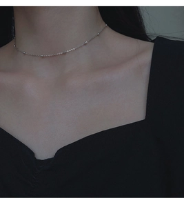 Détail d'un collier choker minimaliste en argent S925 à perles porté par un modèle