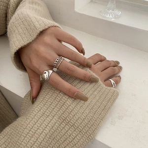 Dettaglio di anelli a catena in argento sterling S925 su una manica in maglia morbida