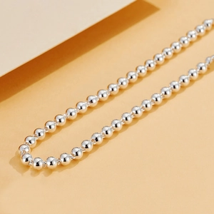 Close-up of polished 925 sterling silver bead necklace with reflective mirror finish
