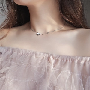 Detail of silver paper plane necklace with a tiny star on model wearing lace