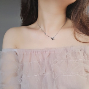 Minimalist silver paper plane necklace worn on collarbone for an elegant and simple look